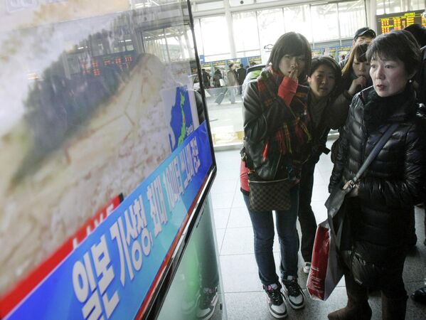 Turistas japoneses assistem a um noticiário de TV sobre um forte terremoto que atingiu seu país na Estação Ferroviária de Seul, Coreia do Sul, em 11 de março de 2011. As letras dizem: &quot;A Agência Meteorológica do Japão alerta para um tsunami&quot;. - Sputnik Brasil