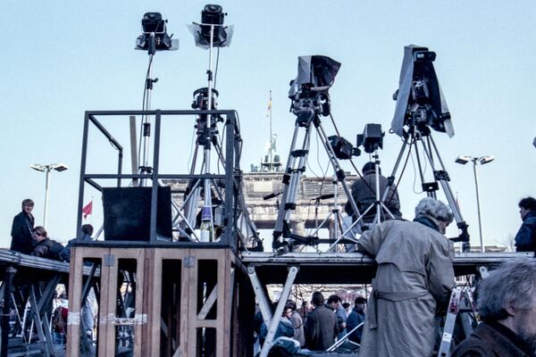 Equipes de filmagem instalam luzes e câmeras em uma plataforma em frente do Portão de Brandemburgo, acima da multidão no Muro de Berlim, em 12 de novembro de 1989, na Alemanha. - Sputnik Brasil