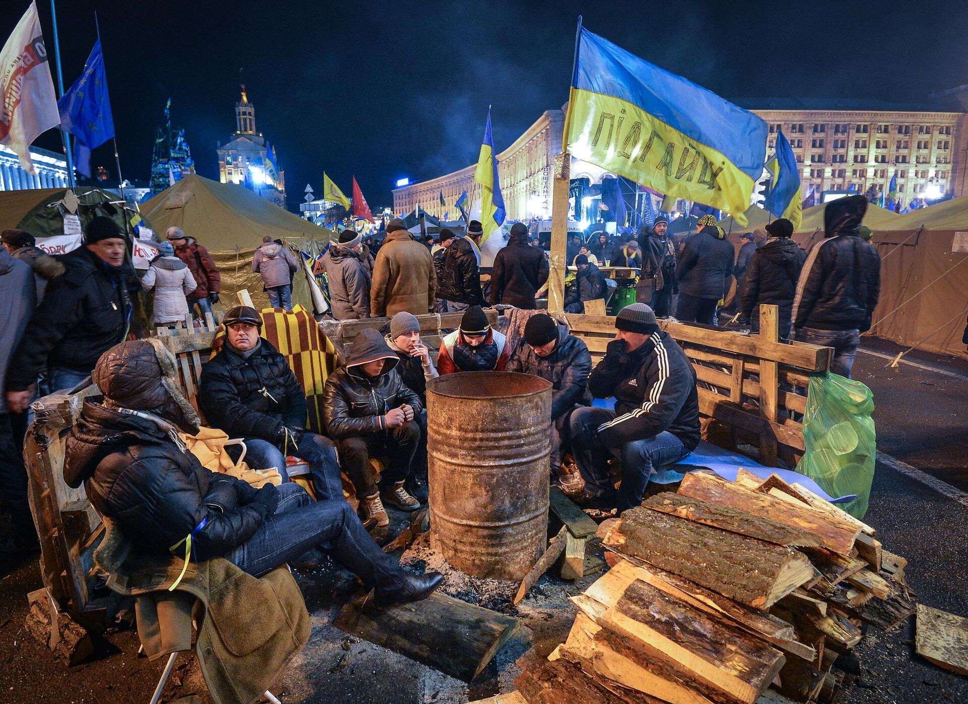 Apoiadores da integração da Ucrânia à União Europeia se aquecem perto do fogo na Praça da Independência, em Kiev. - Sputnik Brasil, 1920, 19.03.2025