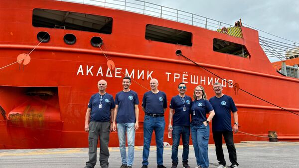 Pesquisadores do Centro Polar e Climático, da UFRGS, à frente do navio quebra-gelo científico Akademik Tryoshnikov, do Instituto de Pesquisa Ártica e Antártica (São Petersburgo, Rússia) durante a cerimônia de lançamento da Expedição Internacional de Circum-Navegação Costeira Antártica, em 22 de novembro de 2024 - Sputnik Brasil