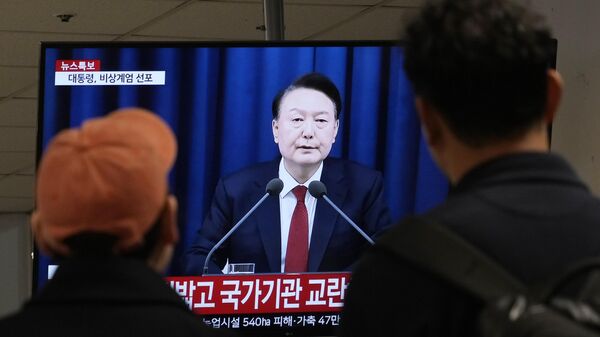 Pessoas assistem a uma tela de TV o briefing televisionado do presidente sul-coreano Yoon Suk Yeol em um terminal de ônibus em Seul, Coreia do Sul, 3 de dezembro de 2024 - Sputnik Brasil