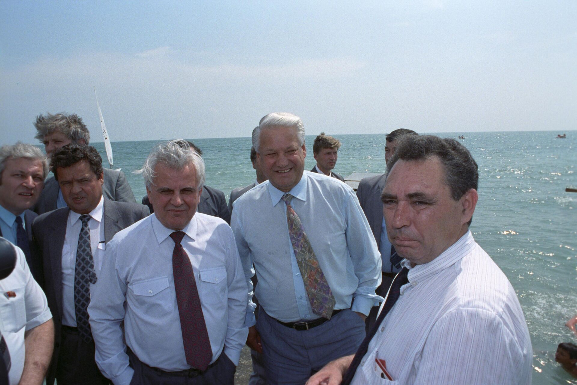 O então presidente da Rússia, Boris Yeltsin (no centro), e seu homólogo ucraniano, Leonid Kravchuk (ao lado de Yeltsin, de gravata vinho), caminham na praia em Dagomys, Rússia, em junho de 1992 (foto de arquivo) - Sputnik Brasil, 1920, 06.12.2024