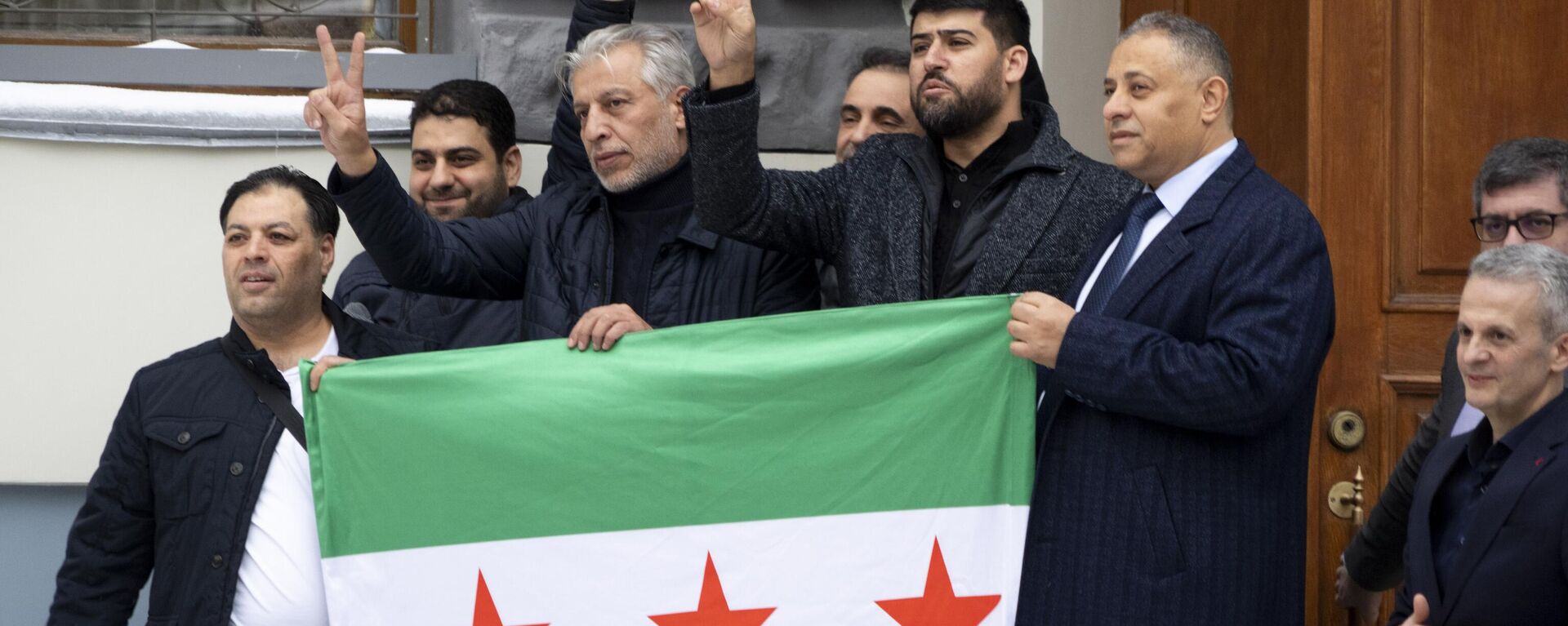 Membros da diáspora síria gesticulam antes de colocar a bandeira da oposição síria no topo da Embaixada da Síria em Moscou. Rússia, 9 de dezembro de 2024 - Sputnik Brasil, 1920, 14.12.2024