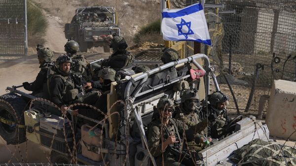 Soldados israelenses com a bandeira nacional em um veículo blindado após cruzarem a cerca de segurança perto da chamada Linha Alfa que separa as Colinas de Golã controladas por Israel da Síria, na cidade de Majdal Shams, 12 de dezembro de 2024. - Sputnik Brasil