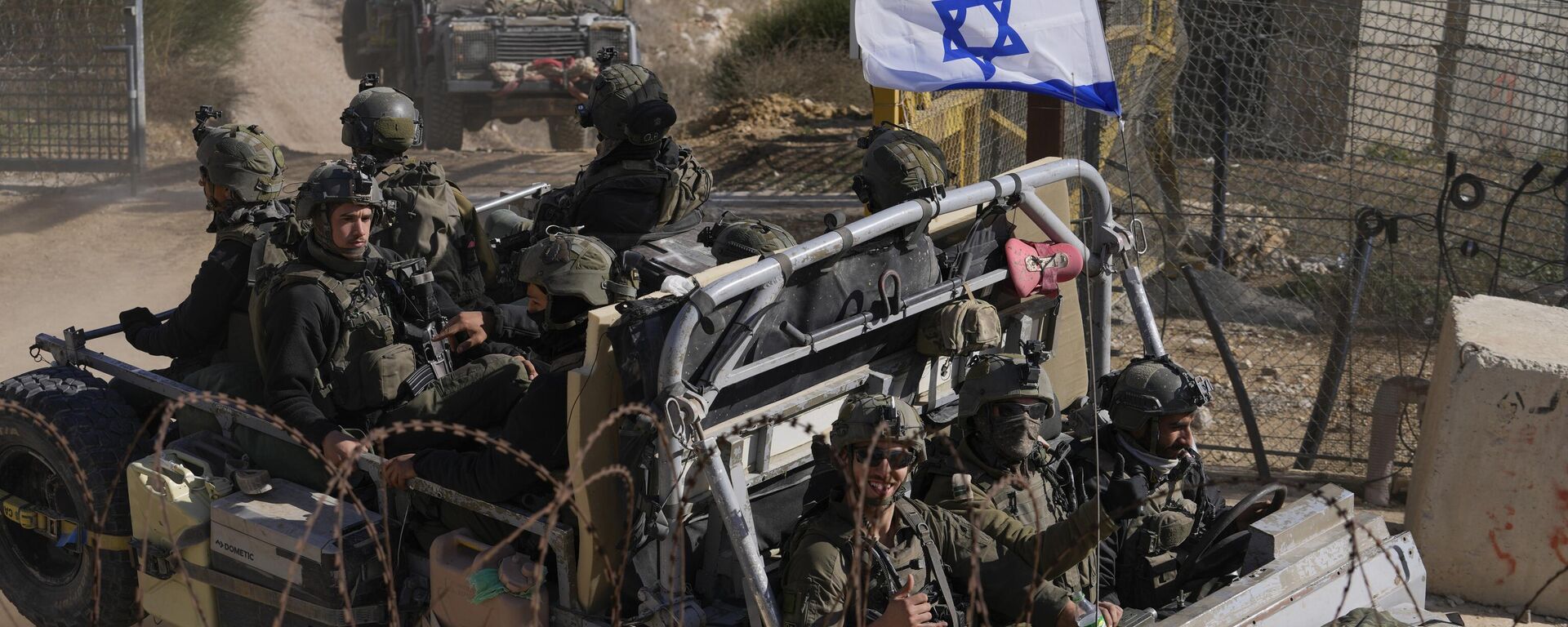 Soldados israelenses com a bandeira nacional em um veículo blindado após cruzarem a cerca de segurança perto da chamada Linha Alfa que separa as Colinas de Golã controladas por Israel da Síria, na cidade de Majdal Shams, 12 de dezembro de 2024. - Sputnik Brasil, 1920, 26.02.2025