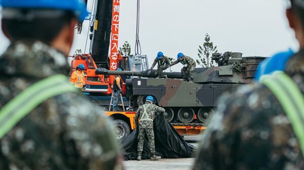 Tanques M1A2T Abrams pintados com camuflagem, sendo transportados em reboques de plataforma sob escolta policial e militar - Sputnik Brasil