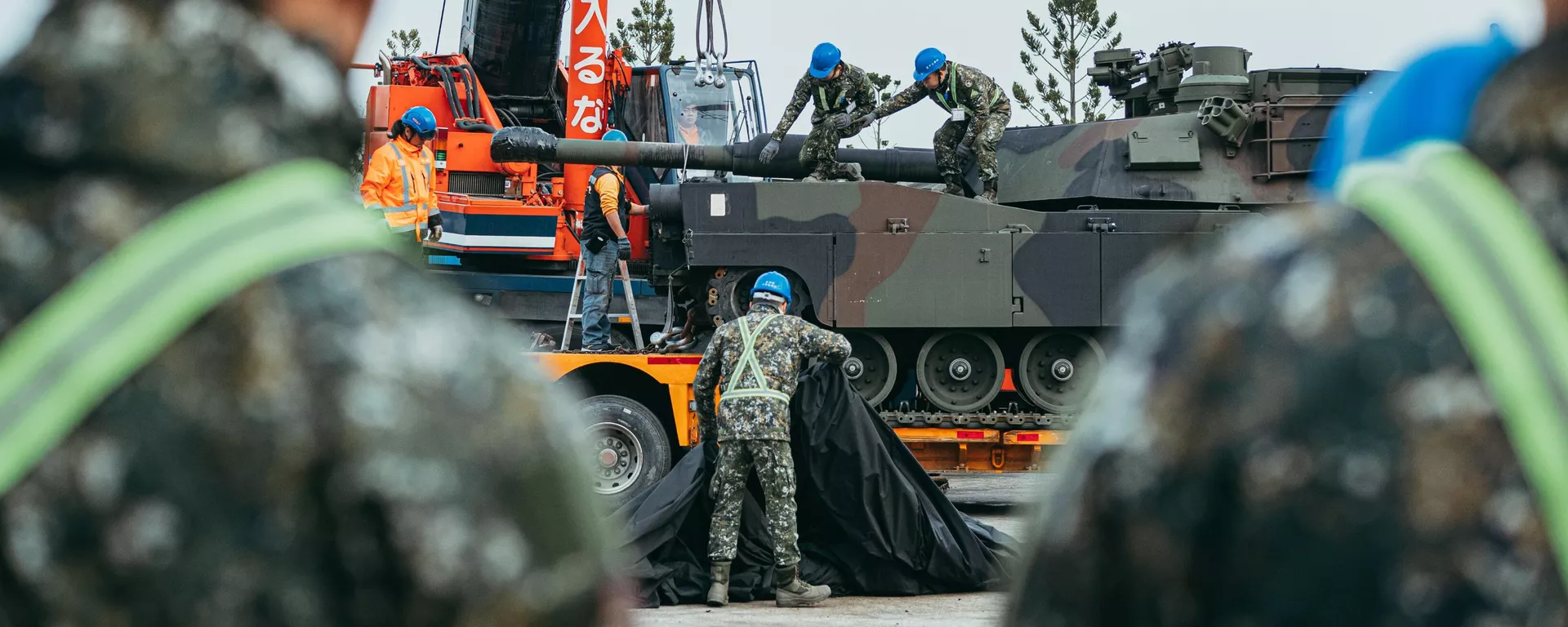 Tanques M1A2T Abrams pintados com camuflagem, sendo transportados em reboques de plataforma sob escolta policial e militar - Sputnik Brasil, 1920, 16.12.2024