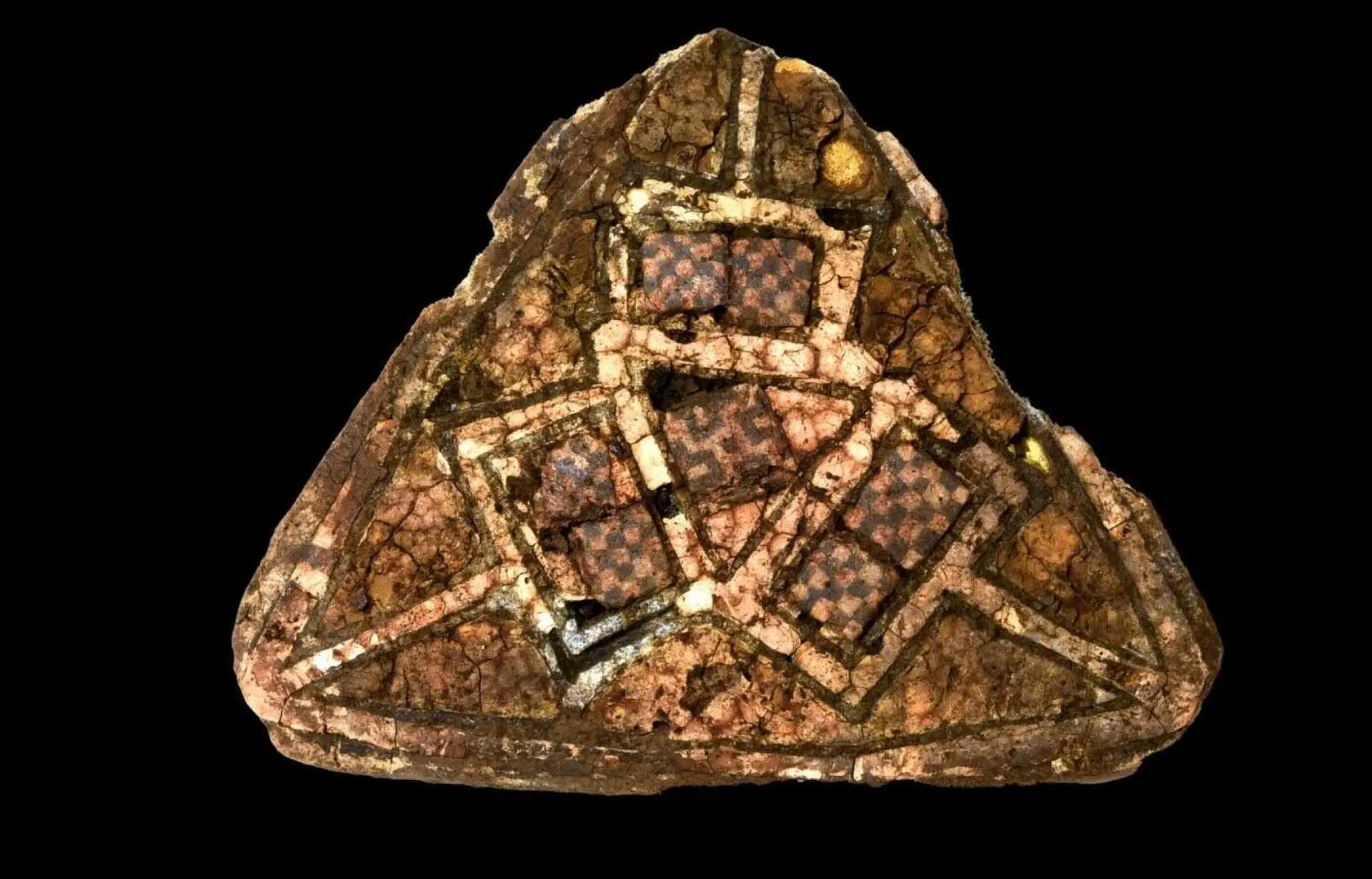 Um broche triangular com mosaico de vidro e esmalte dourado, provavelmente da Irlanda ou da Inglaterra, foi descoberto em uma sepultura dentro de uma fenda na rocha. A sepultura havia sido aberta anteriormente, com restos dos bens funerários encontrados espalhados do lado de fora e ao redor dela - Sputnik Brasil, 1920, 23.12.2024