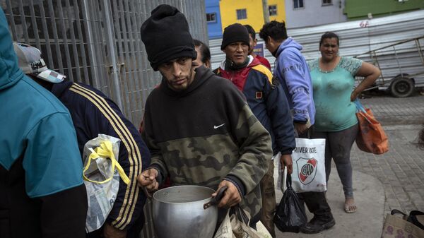 Pessoas esperam na fila por uma refeição gratuita oferecida pela cozinha comunitária da Casa Comunitária del Fondo, no popular bairro de Padre Carlos Mugica, em Buenos Aires, Argentina, 1º de novembro de 2023 - Sputnik Brasil