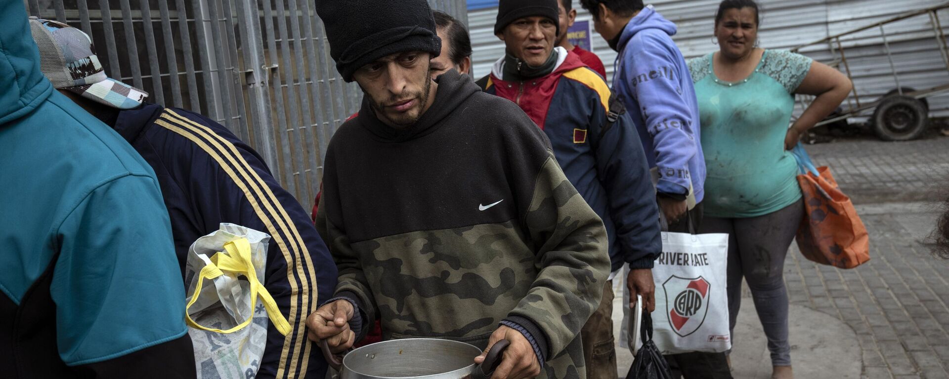 Pessoas esperam na fila por uma refeição gratuita oferecida pela cozinha comunitária da Casa Comunitária del Fondo, no popular bairro de Padre Carlos Mugica, em Buenos Aires, Argentina, 1º de novembro de 2023 - Sputnik Brasil, 1920, 26.12.2024