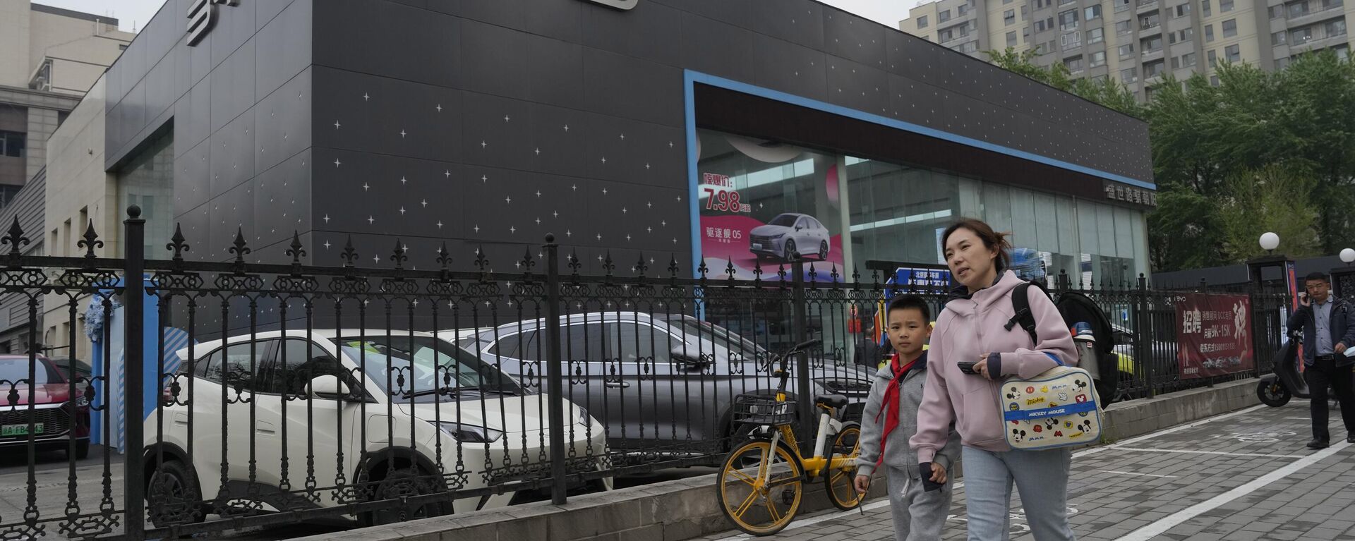 Moradores passam por um veículo elétrico Seagull da montadora chinesa BYD estacionado em um showroom em Pequim, 10 de abril de 2024 - Sputnik Brasil, 1920, 26.12.2024