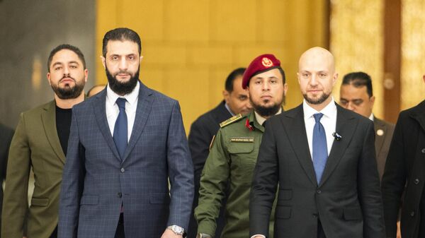 Então líder de facto da Síria, Ahmed al-Sharaa (em primeiro plano, à esquerda), anteriormente conhecido como Abu Mohammad al-Julani, se encontra com Walid Ellafi (à direita), ministro de Estado líbio para comunicação e assuntos políticos, no palácio presidencial em Damasco. Síria, 28 de dezembro de 2024 - Sputnik Brasil