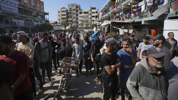 Palestinos se reúnem para receber ajuda distribuída pela UNRWA, a agência da ONU que ajuda refugiados palestinos, no campo de refugiados de Nusairat, Gaza, 5 de novembro de 2024 - Sputnik Brasil