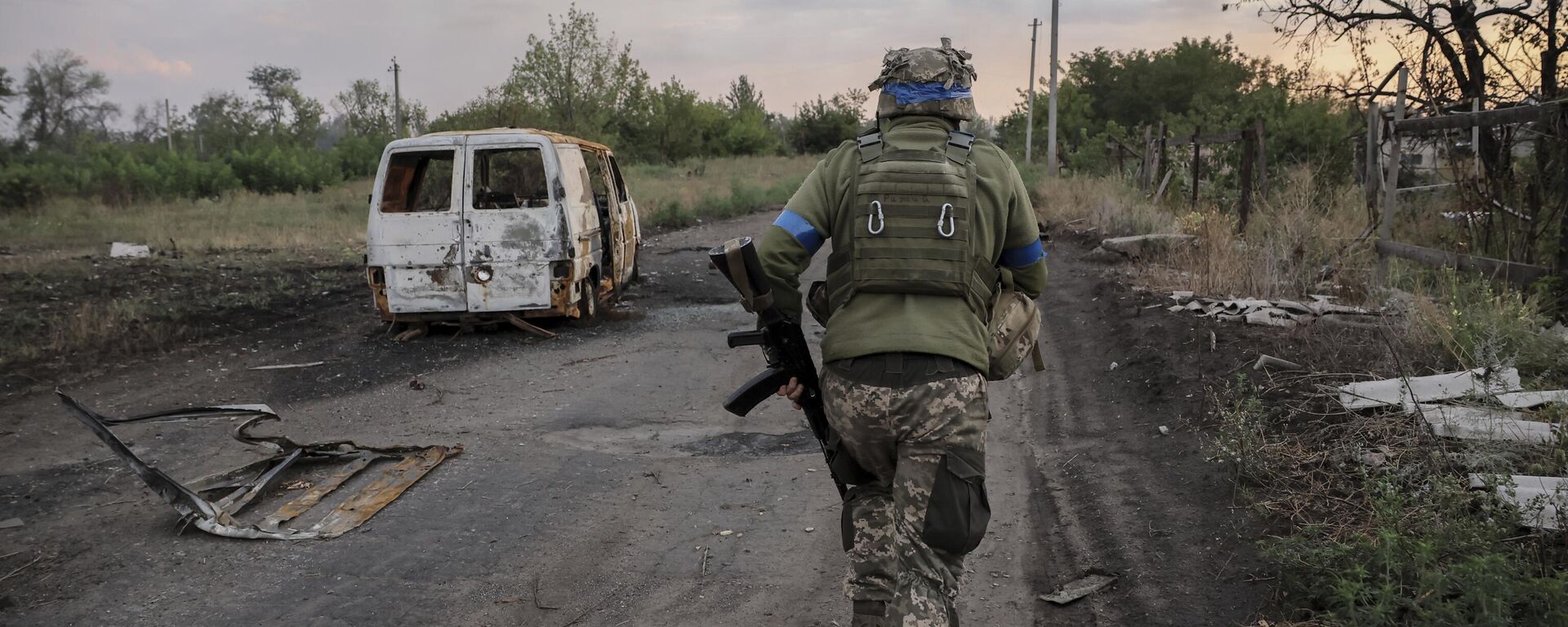 Um militar da 24ª Brigada Mecanizada da Ucrânia passa por um carro danificado na linha de frente na região de Donetsk, 6 de agosto de 2024 - Sputnik Brasil, 1920, 03.01.2025