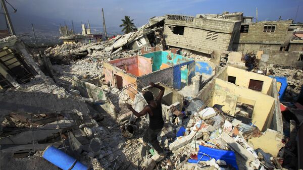 Um homem caminha entre os escombros de um prédio desabado em Porto Príncipe após o terremoto que atingiu o Haiti em janeiro de 2010. - Sputnik Brasil