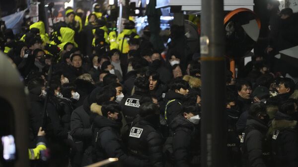 Policiais tentam entrar na residência presidencial da Coreia do Sul, em Seul, enquanto membros do Partido do Poder Popular (PPP) tentam bloqueá-los, em frente ao portão da propriedade. Coreia do Sul, 15 de janeiro de 2025 - Sputnik Brasil