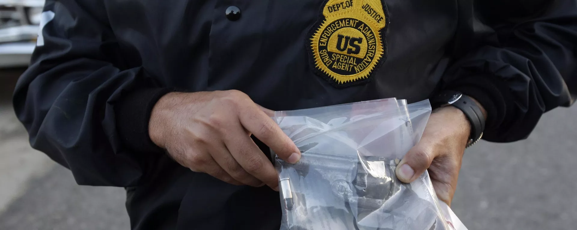 Agente da Administração de Repressão às Drogas (DEA, na sigla em inglês) mostra arma supostamente apreendida de um suposto traficante de drogas após sua prisão durante uma batida em um conjunto habitacional em Mayaguez. Porto Rico, 9 de julho de 2010 - Sputnik Brasil, 1920, 26.08.2025