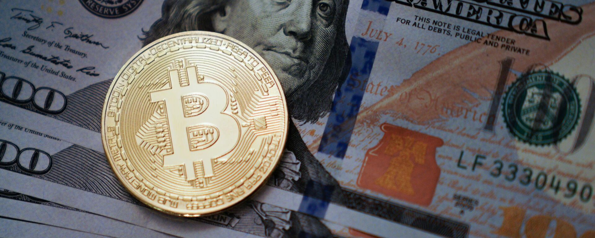 Uma moeda com o emblema do bitcoin sobre dólares americanos - Sputnik Brasil, 1920, 02.02.2025