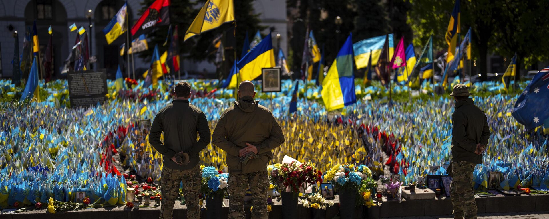 Militares ucranianos ao lado de bandeiras e fotografias ucranianas colocadas em memória de civis e soldados mortos durante o conflito, na Praça da Independência, no centro de Kiev, 20 de abril de 2024 - Sputnik Brasil, 1920, 10.06.2025