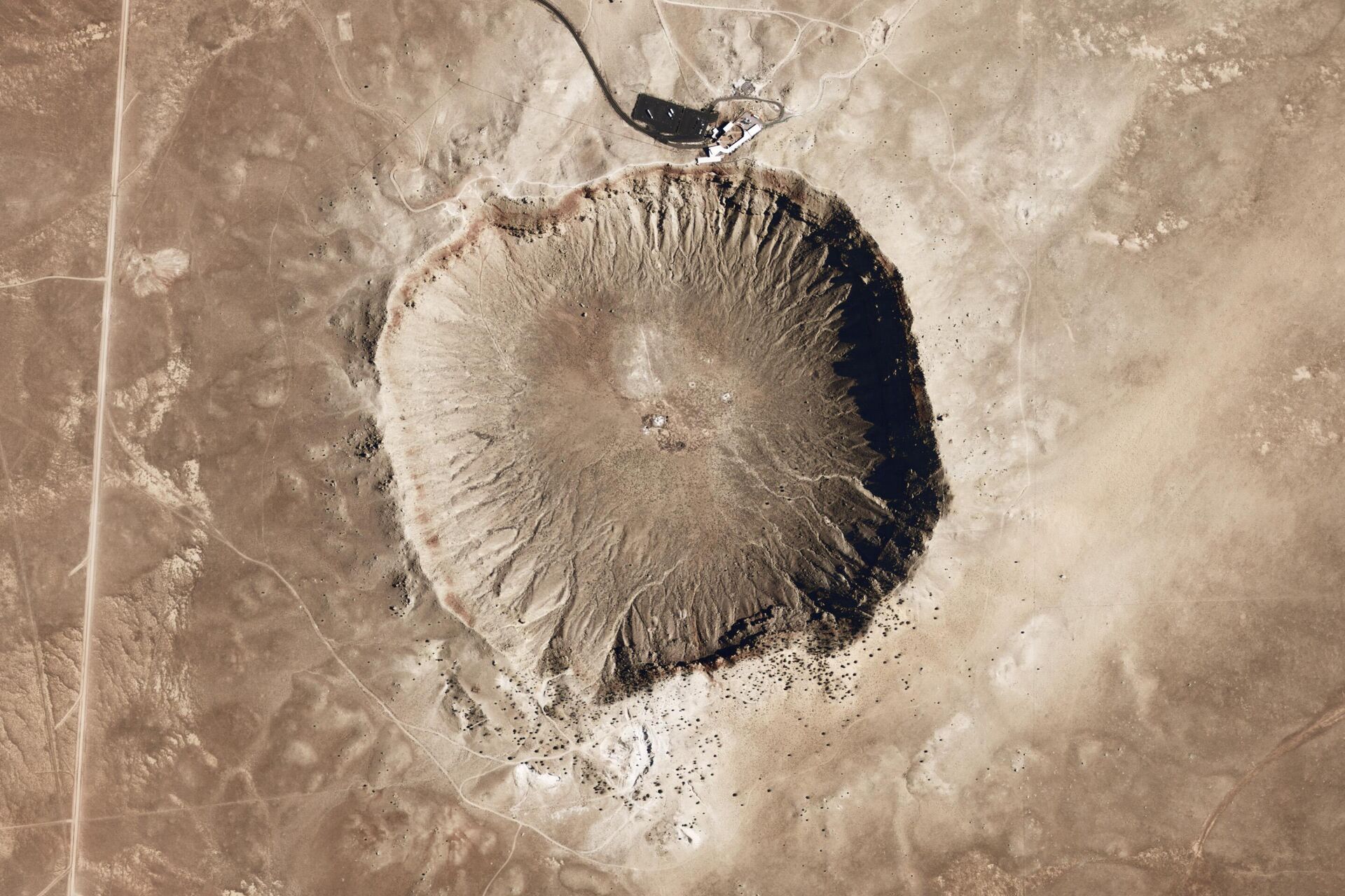 Uma cratera provocada pela queda de um meteoro no Arizona onde se podem ver camadas de calcário e arenito expostos logo abaixo da borda da cratera, assim como grandes blocos de pedra escavados pelo impacto - Sputnik Brasil, 1920, 03.02.2025