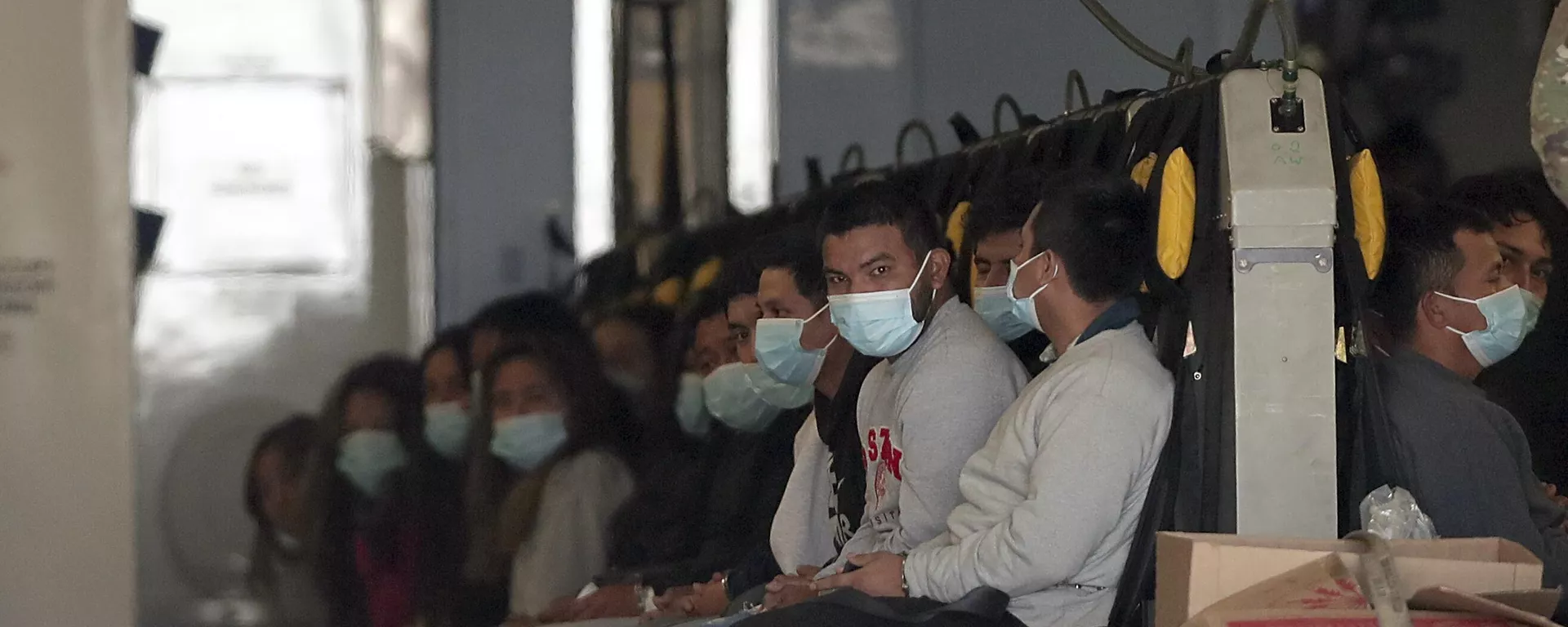 Imigrantes usando máscaras faciais e algemas nas mãos e pés sentam-se em uma aeronave militar em Fort Bliss, em El Paso, Texas, enquanto aguardam para serem deportados. EUA, 30 de janeiro de 2025 - Sputnik Brasil, 1920, 04.02.2025