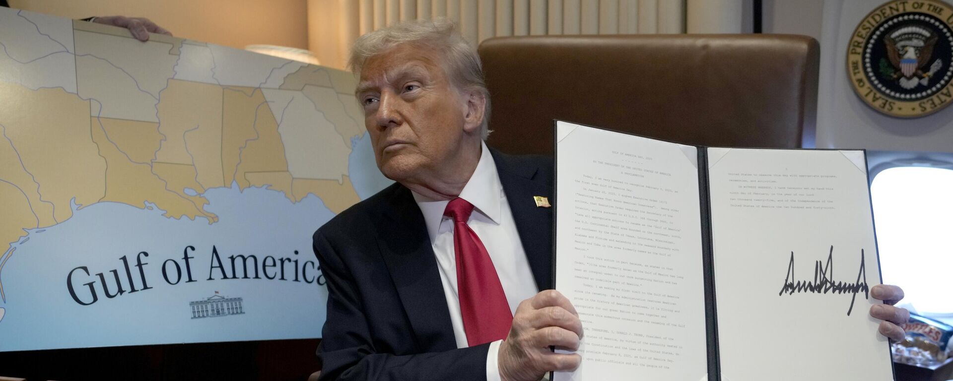 Donald Trump segura uma ordem executiva assinada declarando o dia 9 de fevereiro como o Dia do Golfo da América, a bordo do avião presidencial, Air Force One, em viagem de West Palm Beach, Flórida, para Nova Orleans. EUA, 9 de fevereiro de 2025 - Sputnik Brasil, 1920, 12.02.2025