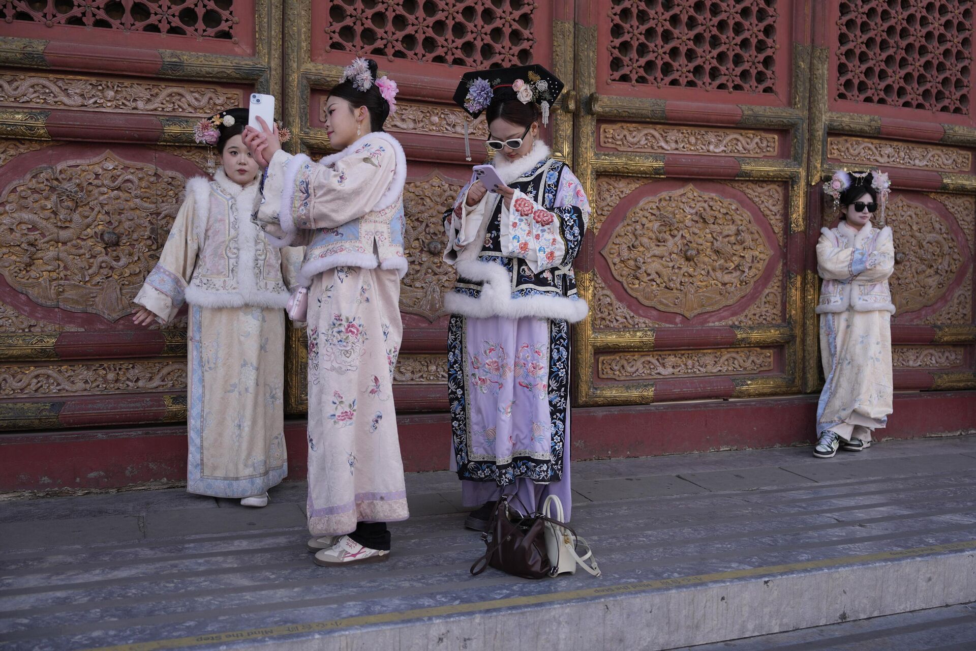 Visitantes vestidos com trajes tradicionais posam para fotos na Cidade Proibida, em Pequim, 21 de fevereiro de 2025 - Sputnik Brasil, 1920, 21.02.2025