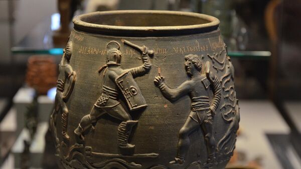 Em 1848, este vaso de cerâmica lindamente decorado foi descoberto em um túmulo romano em West Lodge, em Colchester. Ele data de cerca de 175 d.C. e provavelmente foi feito em Colchester. Quatro gladiadores podem ser vistos na base. Acima deles estão inscritos os nomes Secundus, Mario, Memnon e Valentinus. É um dos melhores exemplos de arte cerâmica conhecidos na Britânia romana - Sputnik Brasil