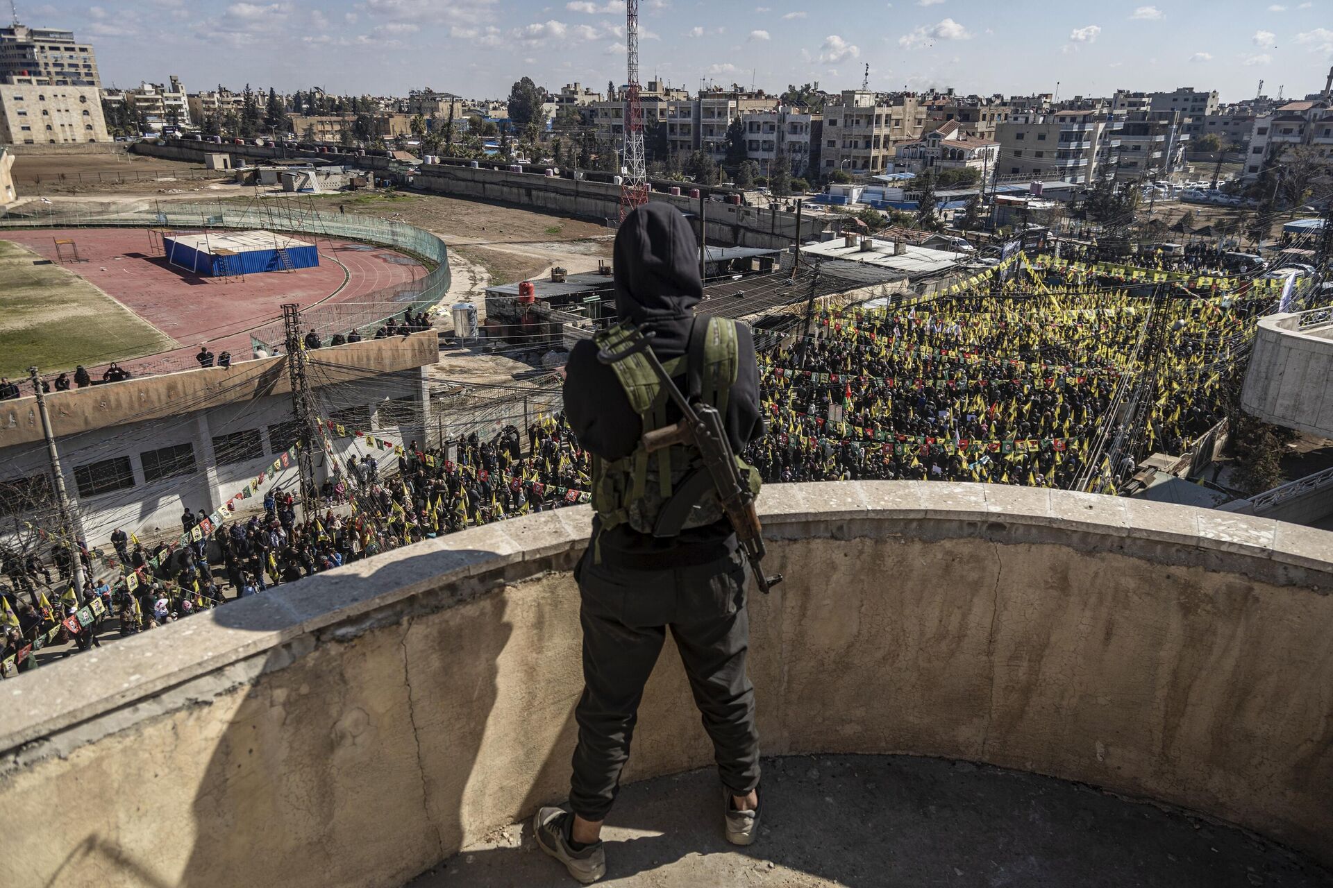 Combatente das Forças Democráticas da Síria (SDF, na sigla em inglês) observa, enquanto centenas de manifestantes marcham para exigir a libertação do líder curdo Abdullah Ocalan em Qamishli, nordeste da Síria, 15 de fevereiro de 2025. - Sputnik Brasil, 1920, 23.02.2025