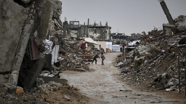 Crianças brincam perto dos escombros de casas e prédios destruídos em Jabalia, norte da Faixa de Gaza, em 7 de março de 2025 - Sputnik Brasil