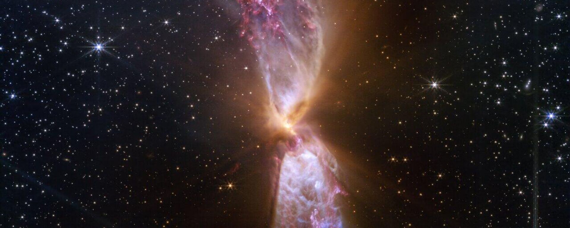 O que parecem chamas gêmeas são conhecidas como Lynds 483 (L483), ejeções de duas estrelas em formação ativa no centro. As próprias estrelas estão escondidas em um pequeno disco opaco de poeira que cabe em um pixel. Esta é a imagem mais detalhada de L483 até o momento, fornecida em luz infravermelha próxima de alta resolução pelo Telescópio Espacial James Webb (JWST) - Sputnik Brasil, 1920, 17.04.2025