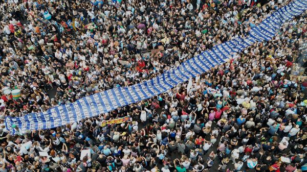 Manifestantes carregam uma faixa com fotos de pessoas desaparecidas durante a ditadura militar argentina (1976-1983) em uma marcha em comemoração ao aniversário do golpe de 1976 no país, em Buenos Aires, Argentina, 24 de março de 2025 - Sputnik Brasil