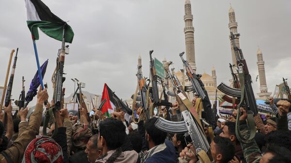 Apoiadores houthis seguram suas armas e entoam slogans durante uma manifestação semanal anti-EUA e anti-Israel em Sanaa, Iêmen, 28 de março de 2025. - Sputnik Brasil