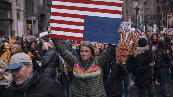 Manifestantes seguram cartazes enquanto saem às ruas e marcham durante um protesto contra Donald Trump em Nova York. EUA, 5 de abril de 2025. - Sputnik Brasil