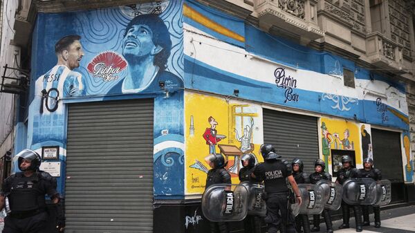 Polícia tenta conter manifestantes de torcidas organizadas que protestavam perto de um mural com as imagens dos jogadores nacionais Lionel Messi e Diego Maradona. Buenos Aires, 12 de março de 2025 - Sputnik Brasil