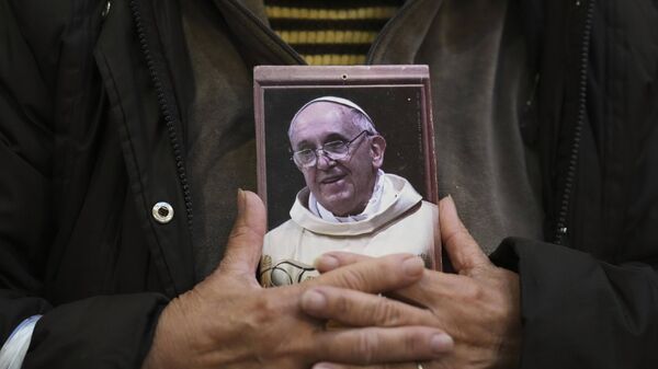 Fiel segura um retrato do falecido Papa Francisco na Basílica de San José de Flores, em Buenos Aires. Argentina, 21 de abril de 2025 - Sputnik Brasil
