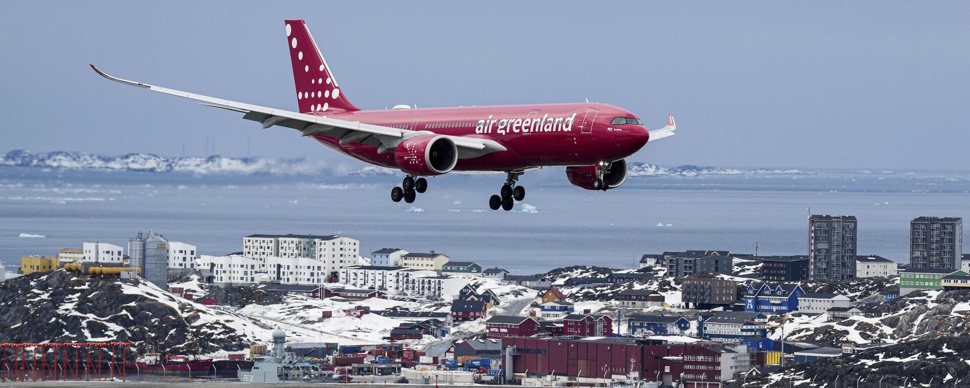 Avião da Greeland Air pousa em aeroporto da capital Nuuk com prédios ao fundo. Groenlândia, 12 de março de 2025 - Sputnik Brasil, 1920, 23.04.2025