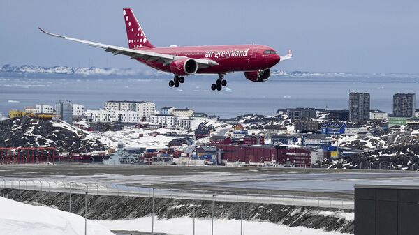 Avião da Greeland Air pousa em aeroporto da capital Nuuk com prédios ao fundo. Groenlândia, 12 de março de 2025 - Sputnik Brasil