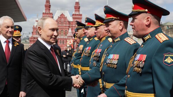 O ministro da Defesa russo, Andrei Belousov (E) e o presidente russo, Vladimir Putin, na Praça Vermelha de Moscou durante o desfile militar que marca o 80º aniversário do Dia da Vitória, 9 de maio de 2025 - Sputnik Brasil