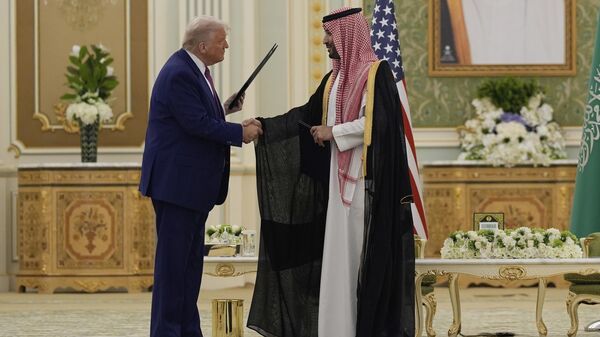 O presidente Donald Trump (E) e o príncipe herdeiro saudita Mohammed bin Salman apertam as mãos após trocar documentos durante uma cerimônia de assinatura no Palácio Real em Riad, Arábia Saudita, 13 de maio de 2025 - Sputnik Brasil