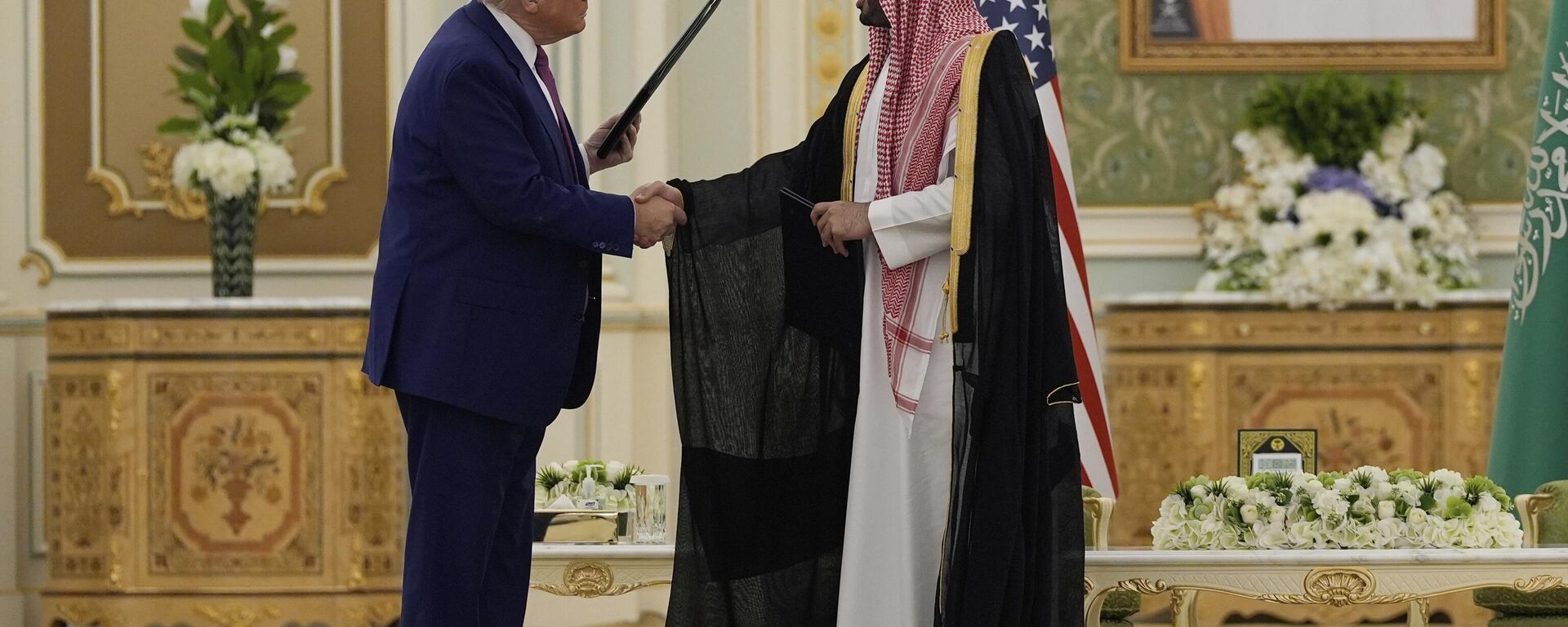 O presidente Donald Trump (E) e o príncipe herdeiro saudita Mohammed bin Salman apertam as mãos após trocar documentos durante uma cerimônia de assinatura no Palácio Real em Riad, Arábia Saudita, 13 de maio de 2025 - Sputnik Brasil, 1920, 14.05.2025
