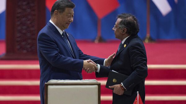O presidente chinês Xi Jinping (E), aperta a mão do presidente colombiano Gustavo Petro após proferir seu discurso de abertura na cerimônia de abertura da Quarta Reunião Ministerial do Fórum da China e da Comunidade de Estados Latino-Americanos e Caribenhos (CELAC), em Pequim, 13 de maio de 2025 - Sputnik Brasil