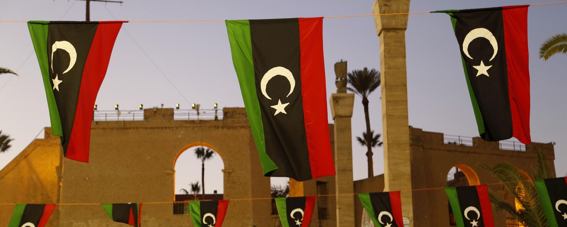 Bandeiras da Líbia são exibidas enquanto as pessoas celebram o Dia da Revolução de Fevereiro na Praça dos Mártires em Trípoli, Líbia, 18 de fevereiro de 2022 - Sputnik Brasil, 1920, 18.03.2026