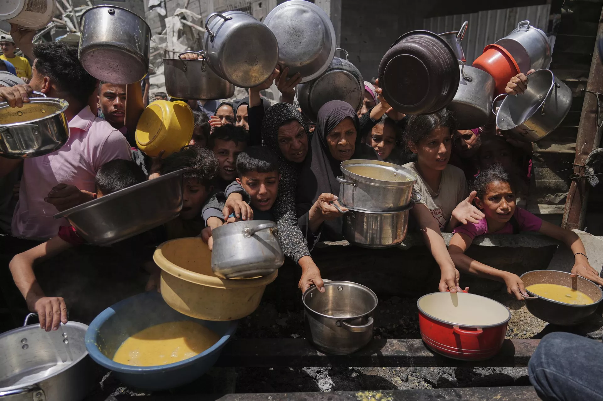 Palestinos tentam obter alimentos doados em cozinha comunitária em Jabalia, no norte da Faixa de Gaza,19 de maio de 2025 - Sputnik Brasil, 1920, 23.05.2025