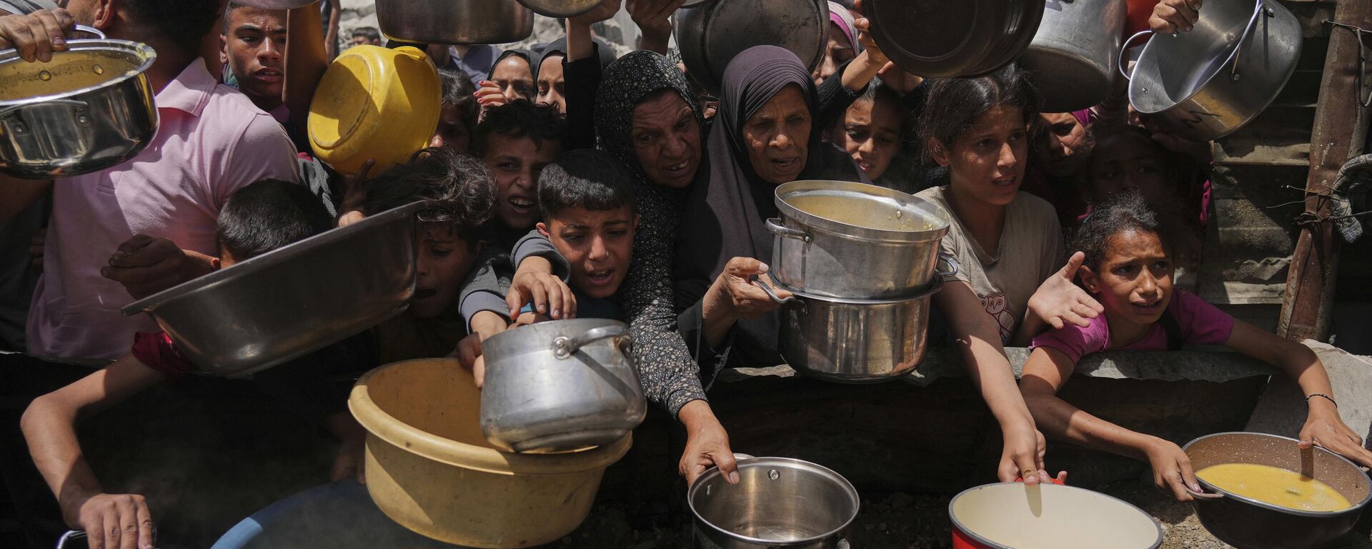 Palestinos tentam obter alimentos doados em cozinha comunitária em Jabalia, no norte da Faixa de Gaza, em 19 de maio de 2025 - Sputnik Brasil, 1920, 08.07.2025