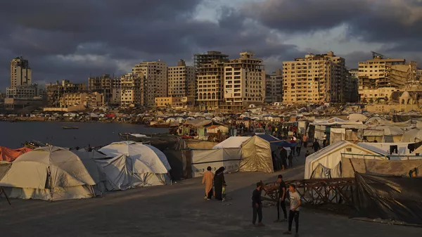 Palestinos caminham por um acampamento improvisado no porto da Cidade de Gaza, 22 de maio de 2025 - Sputnik Brasil