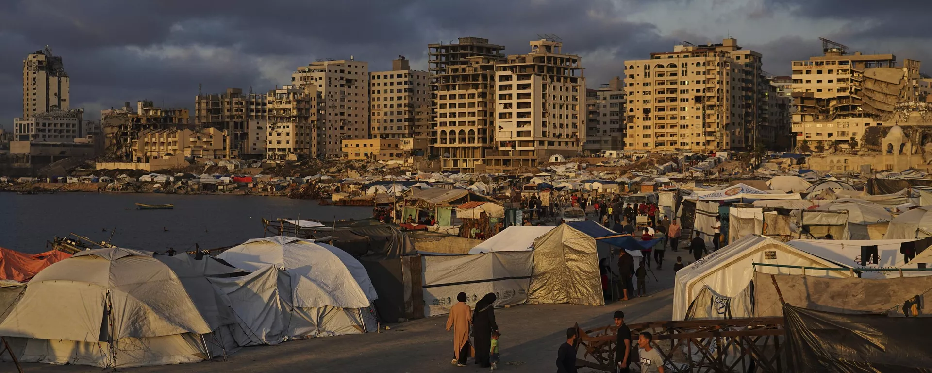 Palestinos caminham por um acampamento improvisado no porto da Cidade de Gaza, 22 de maio de 2025 - Sputnik Brasil, 1920, 01.06.2025