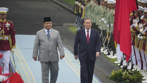 Li Qiang, à direita, e Prabowo Subianto, à esquerda, inspecionam uma guarda de honra durante a cerimônia de boas-vindas antes do encontro em Jacarta. Indonésia, 25 de maio de 2025 - Sputnik Brasil