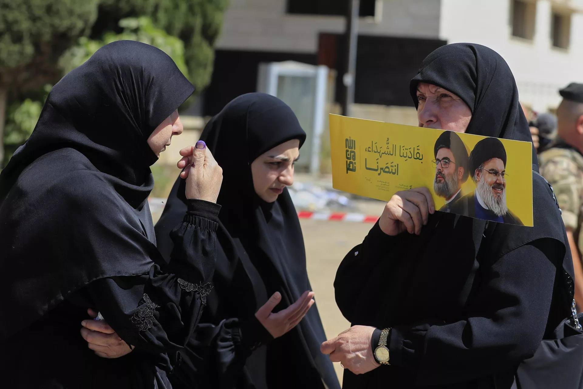 Eleitora segura cartaz com imagens do ex-líder do Hezbollah, Hassan Nasrallah, à direita, e seu primo e sucessor Hashem Safieddine, perto de uma seção eleitoral durante as eleições municipais na cidade de Nabatieh, sul do Líbano, 24 de maio de 2025 - Sputnik Brasil, 1920, 29.05.2025