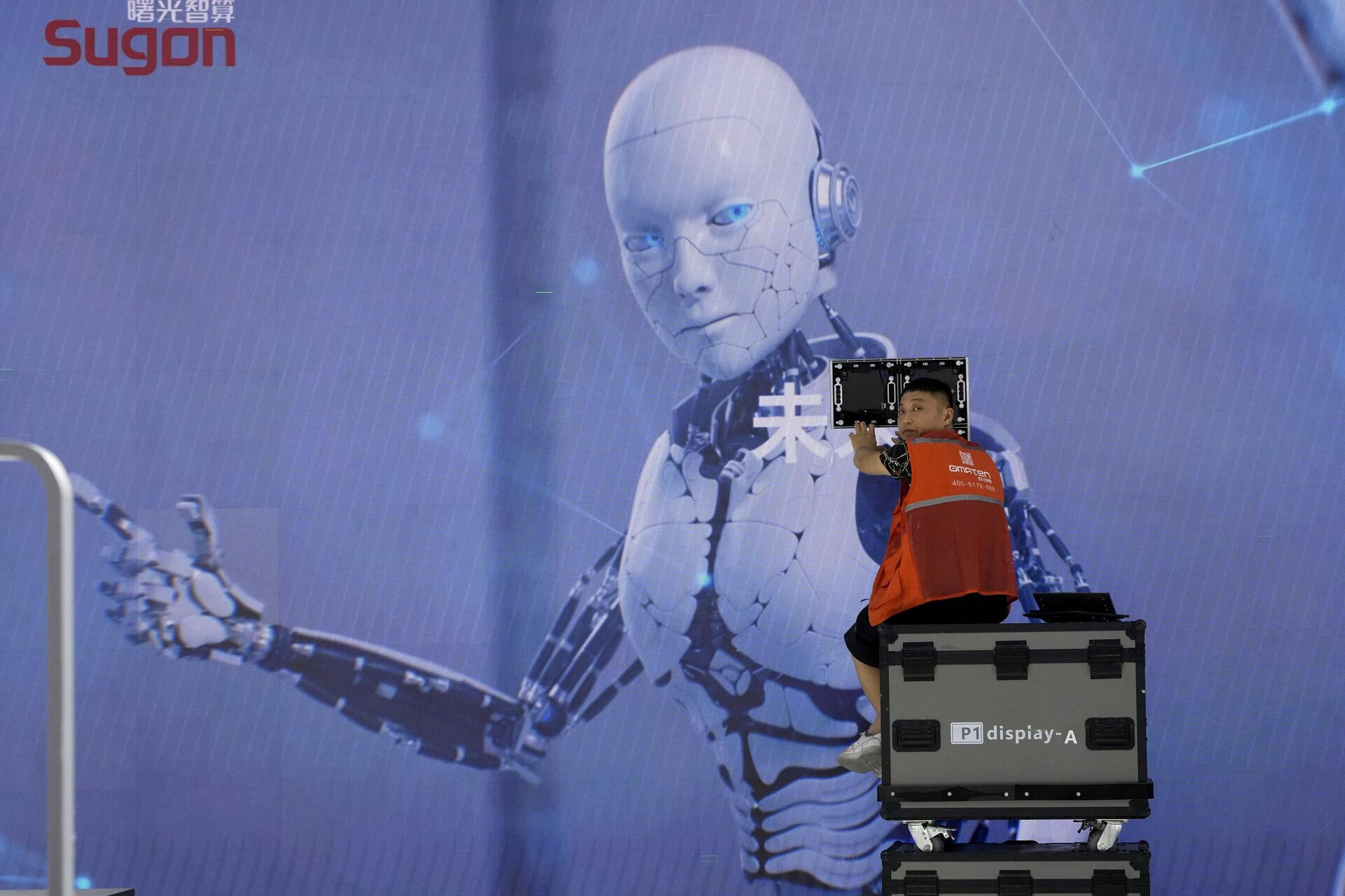 Trabalhador monta estande da Sugon, uma fabricante chinesa de supercomputadores, durante a Conferência Mundial de Inteligência Artificial realizada em Xangai, 5 de julho de 2023. (foto de arquivo) Trabalhador monta estande da Sugon, uma fabricante chinesa de supercomputadores, durante a Conferência Mundial de Inteligência Artificial realizada em Xangai, 5 de julho de 2023. (foto de arquivo)